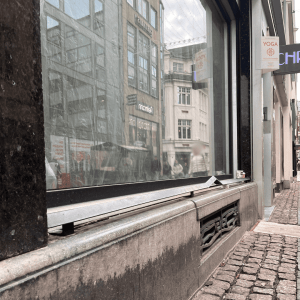 Fenstersims eines Geschäfts mit aufgesetzter Metallleiste.